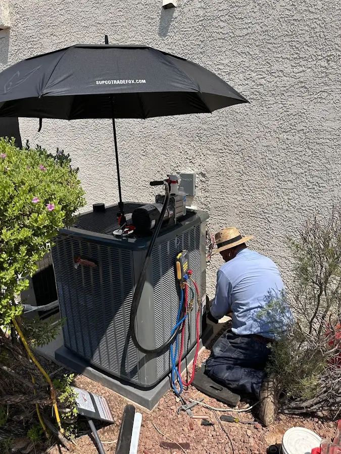 HVAC technician performing outdoor AC maintenance in Hollis